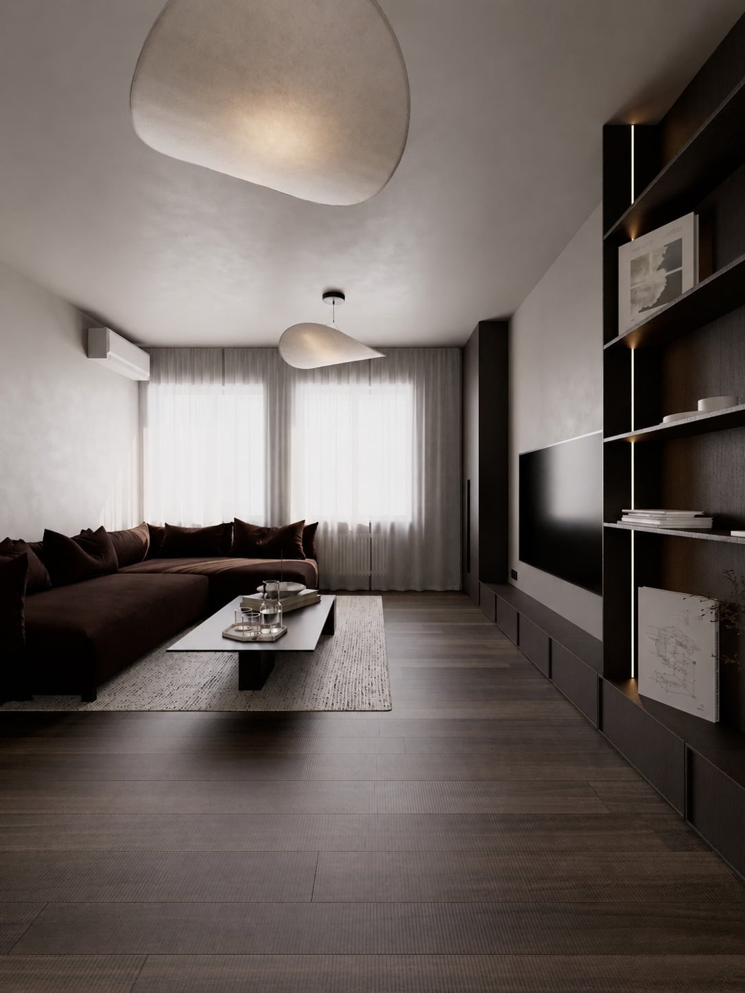 A living room corner with an oxblood sofa beneath curtained windows, facing a dark joinery wall with a television.