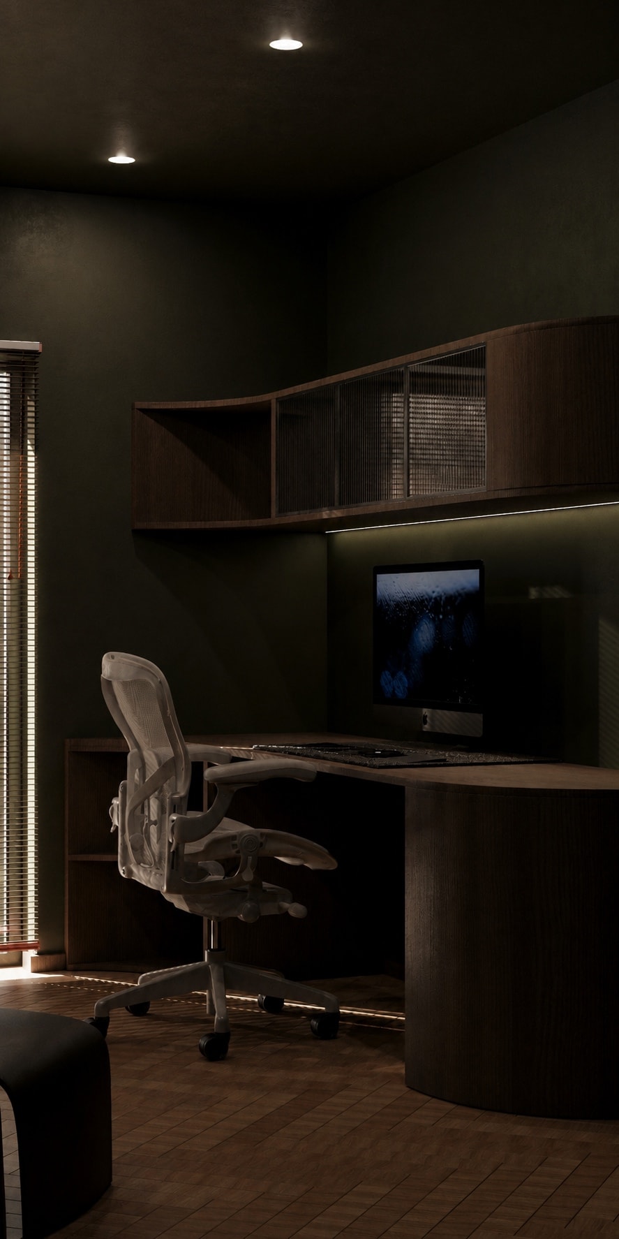A built-in desk and monitor beneath curved dark shelving, seen in a narrow vertical framing.