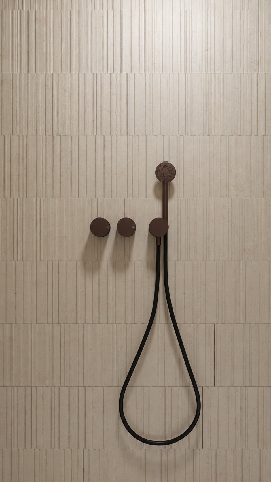 A close study of matt bronze shower controls and a flexible handset against vertical fluted stone tiling.