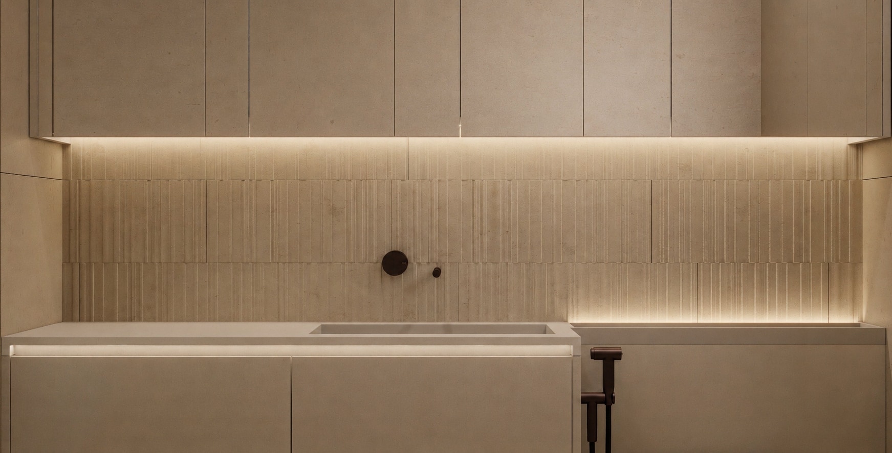 A wide view along a bathroom vanity wall in fluted stone, lit by a continuous concealed strip above the counter.
