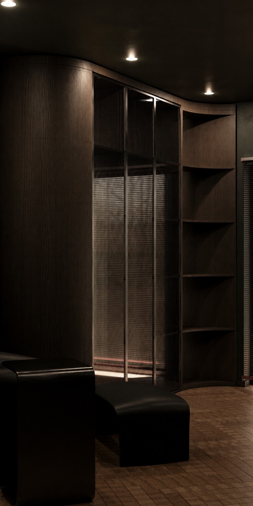 A close detail of curved dark joinery with a reeded glass panel, beside a dark leather bench.