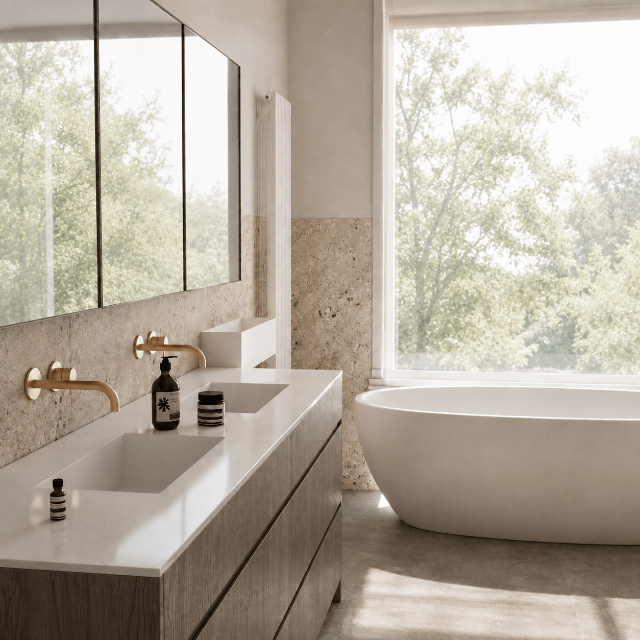 A sunlit bathroom with a long double vanity and freestanding bath beside a large garden window.