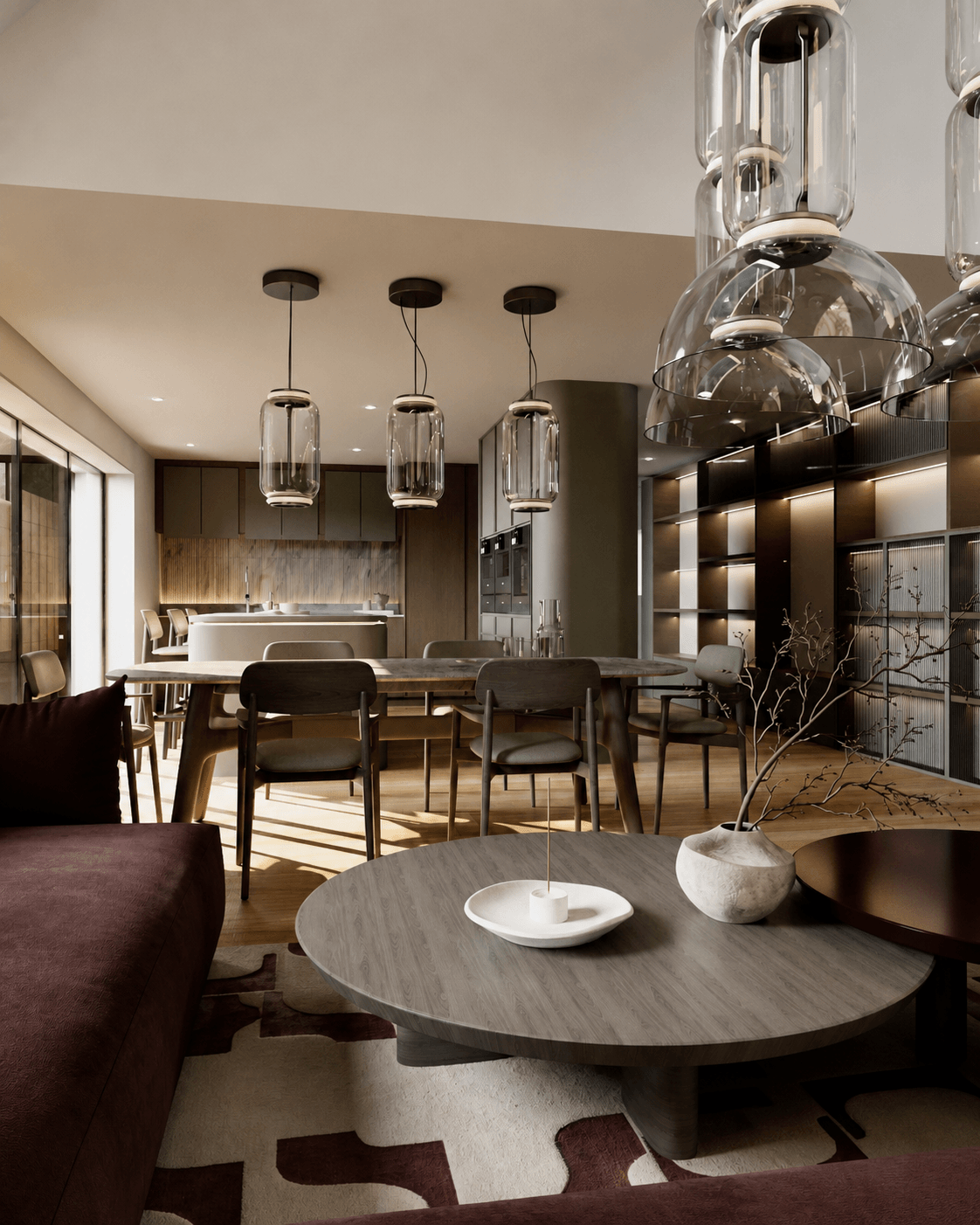 An open-plan kitchen and dining room with muted olive cabinetry, a stone island, a timber table and sculptural glass pendant lights.