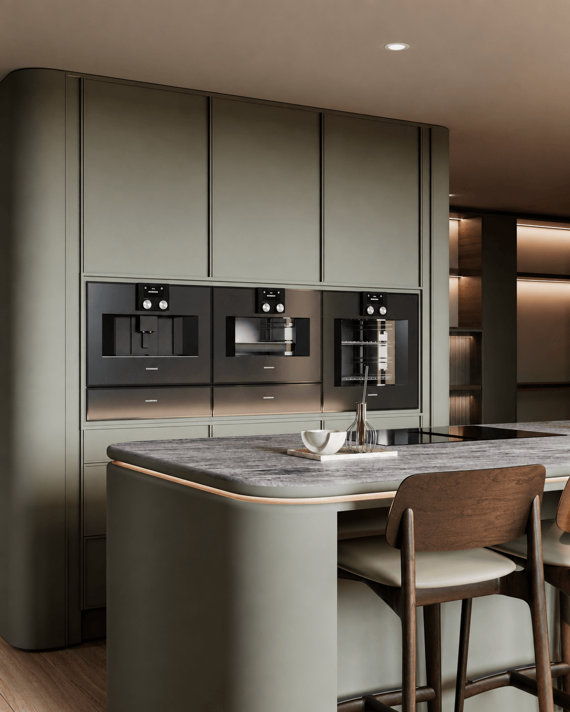A curved olive kitchen island with a veined stone worktop, facing a full-height appliance wall and timber bar chairs.