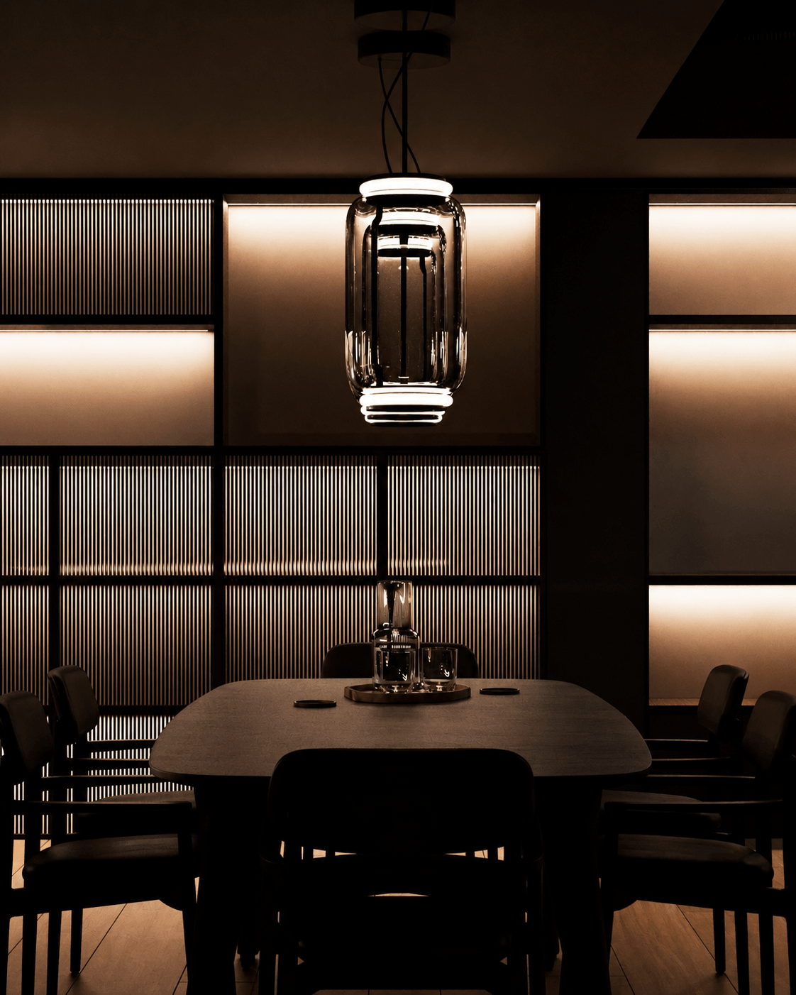 A dark dining room with a sculptural glass pendant and illuminated ribbed joinery forming the backdrop.
